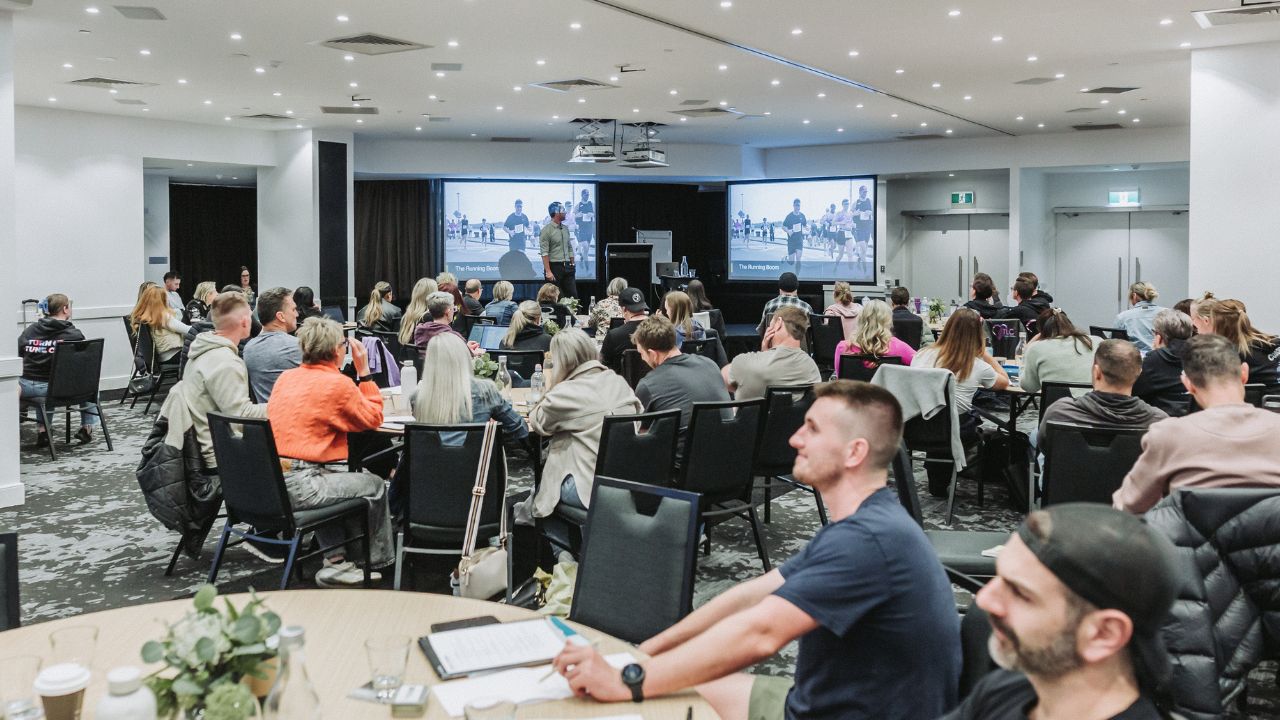 Fitness business owner leading coaches during a team meeting.